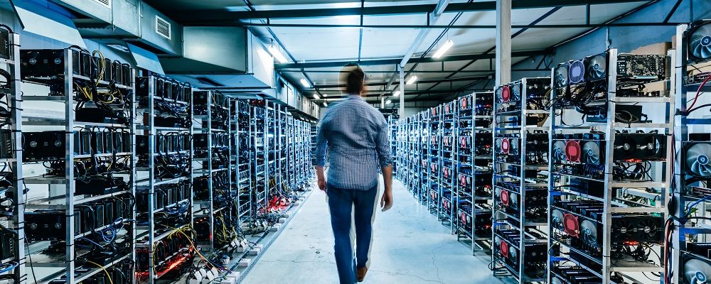 IT business owner walking in high tech data center full of servers and computers. Bitcoin and crypto currency mining farm.